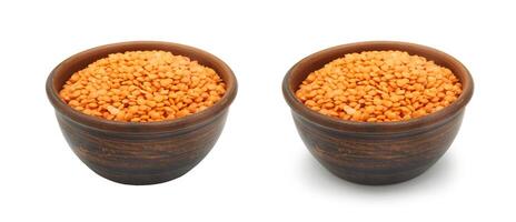 red lentils in clay bowl on white background, isolated and with shadow photo