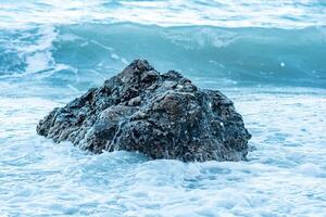 coastal rock in the surf during a storm photo