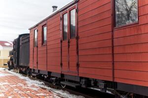 Clásico furgón con un vapor locomotora a el estación en invierno foto