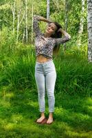 young woman stands on a board with nails doing yoga practice outdoors photo