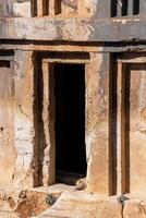 entrance to an ancient stone tomb carved into the rock photo