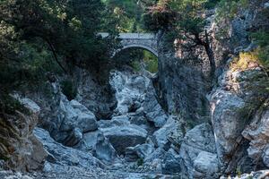 ancient Roman bridge over a shady gorge in the Kesme Bogazi canyon, Turkey photo