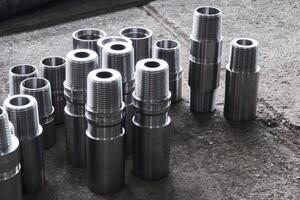 industrial background - new shiny steel hardware, parts of turbodrills of various diameters are in the workshop photo