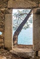 through the door in the ruins of an antique house you can see the sea photo