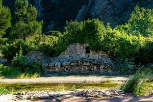 restos de antiguo edificios en el antecedentes de montañas en el antiguo ciudad de olimpos, Turquía foto