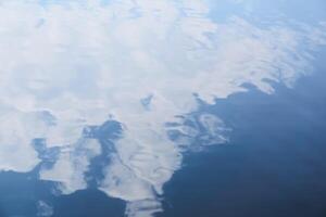 blurred abstract background - waves on the water surface with cloud reflection in the sky photo