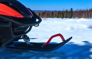 snowmobile ski while driving on snowy winter landscape photo