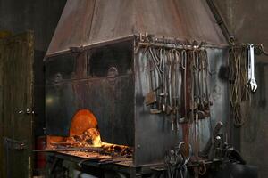 forge furnace with burning flame and blacksmith tools photo