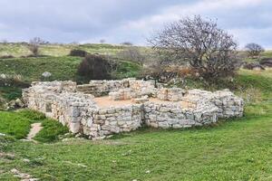 ruins of the foundations of an antique house among the hills photo