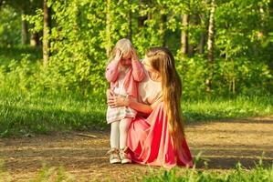 mom asks her little daughter what happened during a walk in the park photo