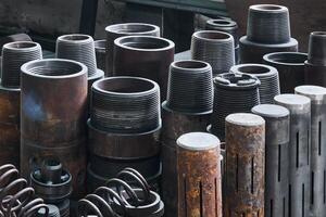 industrial background - rusty hardware, parts of turbodrills of various diameters are in the workshop photo