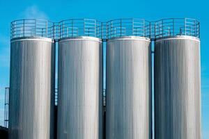 metal industrial silo towers for bulk and liquid materials against the sky photo