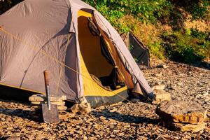 caminata acampar en un rocoso costa, Hazme marco tienda foto