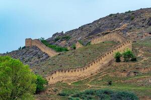 medieval fortaleza pared en un montaña pendiente, shamil gunib fortaleza en daguestán foto