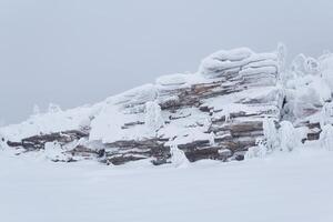 winter landscape - bizarre rock and trees on the mountain plateau are covered with deep snow photo