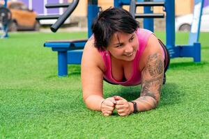 muscular plump woman exercising on the sports ground photo