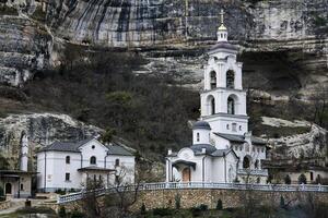 bell tower of Assumption Monastery of the Caves on the background of a rock in Bakhchisarai, Crimea photo