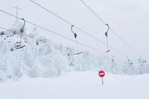 prohibitory road sign No entry against the background of an empty ski surface lifts on a snowy ski slope photo