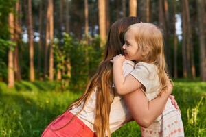 woman hugs her toddler child outdoors photo