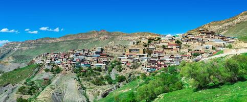 panorama of the entire ancient mountain village Chokh on a rocky slope in Dagestan photo