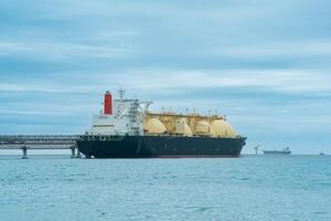 licuado natural gas portador petrolero durante cargando a un lng costa afuera Terminal, en el distancia el petróleo exportar terminal es visible en el mar foto