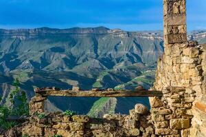 bench over an abyss in the ruins of the historic mountain village of Gamsutl in Dagestan photo