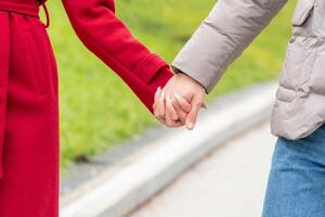 mano en mano juntos, manos de un Pareja en amor caminando al aire libre foto