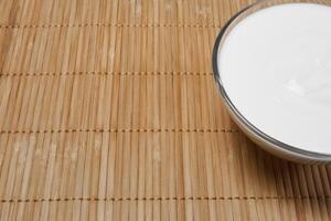 still life background with fragment of bowl with sour cream on the table photo