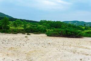 landscape of Kunashir island, tephra beach of a hot lake at the bottom of Golovnin volcano caldera photo