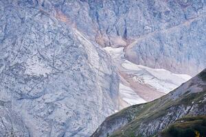 cold alpine landscape with a glacier hidden between the spurs of the mountain photo