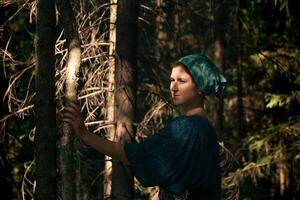 joven mujer en tradicional gente campesino ropa en conífero bosque foto