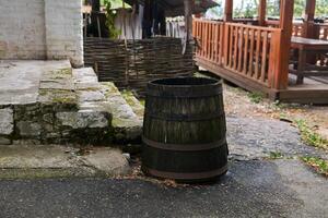 antiguo de madera agua barril soportes por el porche foto