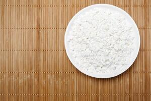 bowl with cottage cheese on the table, top view photo