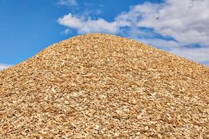 huge pile of wood chips against the sky photo