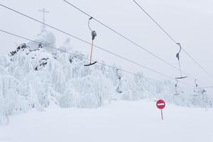 prohibitory road sign No entry against the background of an empty ski surface lifts on a snowy ski slope photo