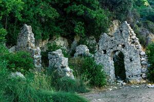 restos de antiguo edificio en el antecedentes de montañas en el antiguo ciudad de olimpos, Turquía foto