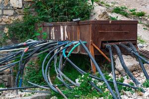 makeshift plumbing in a mountain village, water from a spring enters the tank through a pipe and is distributed to houses using hoses photo