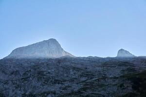 mountain peaks are illuminated by the sun rays, while the walls of the gorge are in the shade photo