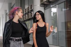 two teen girls walking down the street and talking photo