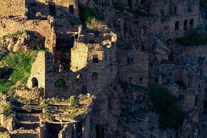 evening view of the ruins of the ghost village of Gamsutl, illuminated by the last rays of the sun photo