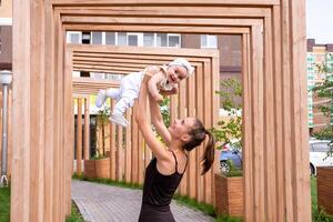 happy mom with baby daughter play in the city courtyard photo