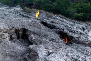 constantly burning fire at the place of a natural gas emission on Mount Chimaera Yanartas, Turkey photo
