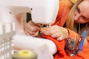 seamstress changes the needle on a sewing machine photo