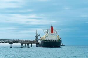 liquefied natural gas carrier tanker during loading at an LNG offshore terminal, in the distance the oil export terminal is visible in the sea photo