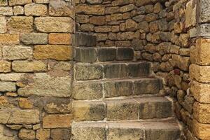 passage with a spiral staircase in an ancient stone wall photo