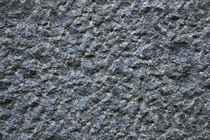 background, texture - the surface of a roughly hewn granite block photo