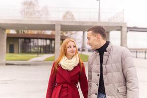 young couple walking in the autumn coastal park photo