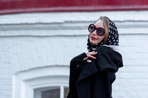 young woman in headscarf in retro style walking down the street photo