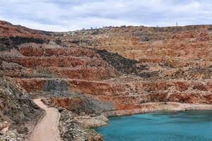 old limestone quarry with a blue lake at the bottom photo