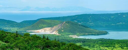 paisaje de kunashir isla, lagos y lava domos en el centrar de golovnin volcán caldera, el isla de Hokkaido es visible en el distancia en el mar foto